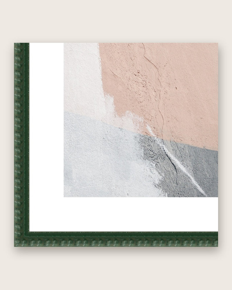 Close-up of a dark green bobbin moulding corner with a white mount board around a square print