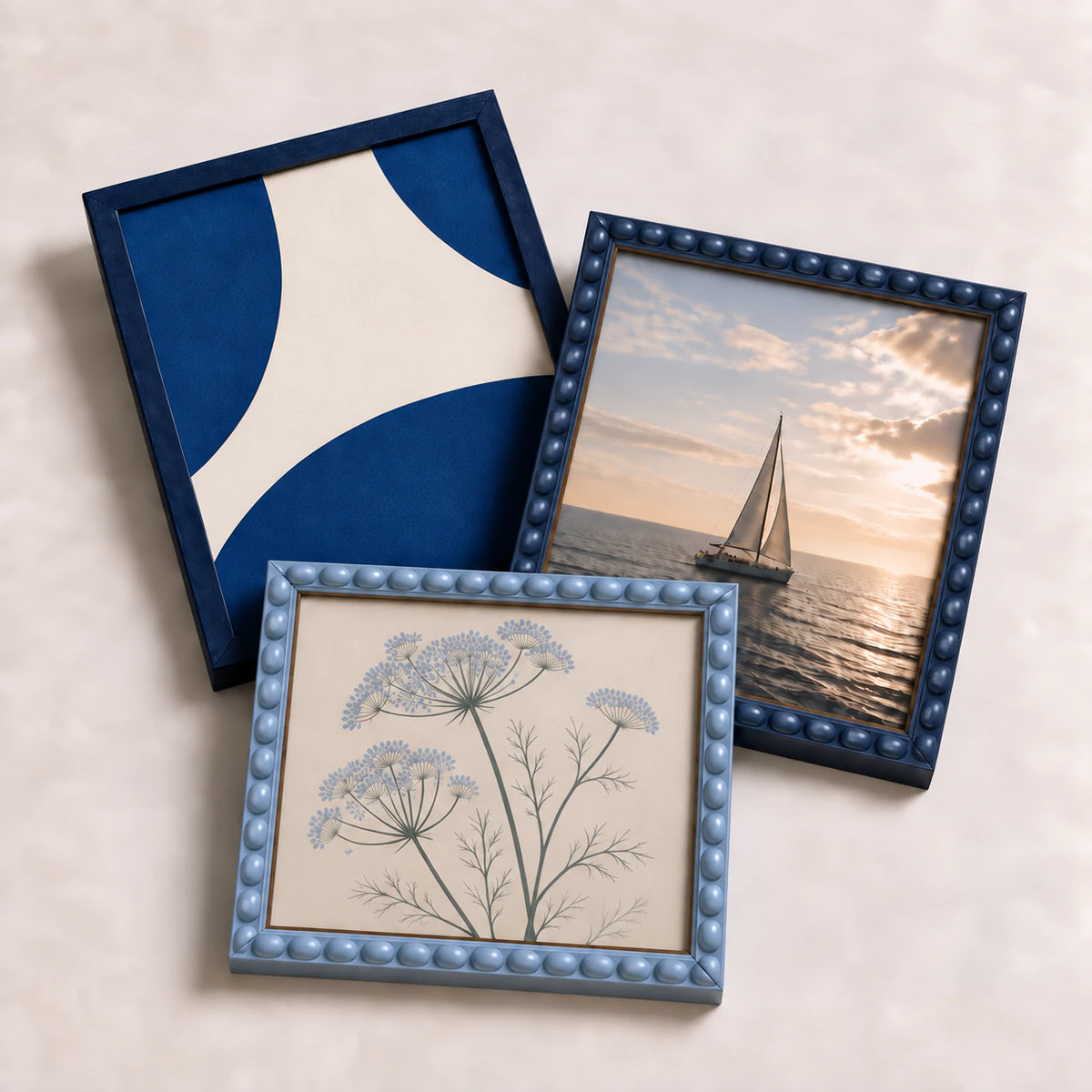 A collection of blue picture frames lying flat with varied edge-to-edge artwork