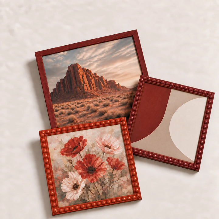 A collection of red picture frames lying flat with varied edge-to-edge artwork