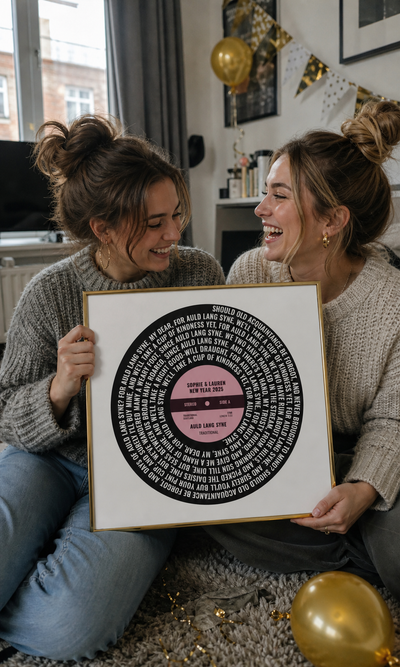 Friends holding a personalised Auld Lang Syne vinyl lyrics print