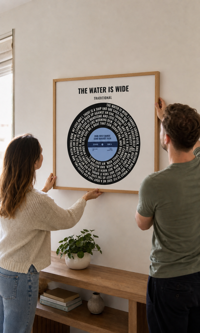 Newlywed couple hanging their personalised vinyl lyrics print