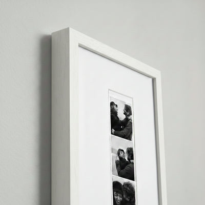 Photo strip in a white wood frame