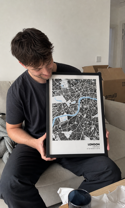 Customer holding a personalised London map in their new home