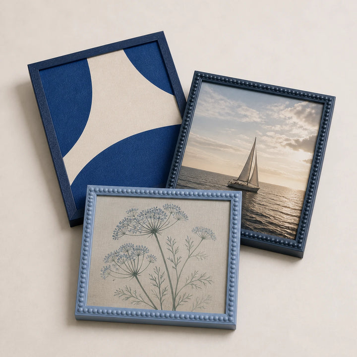 A collection of blue picture frames lying flat with varied edge-to-edge artwork