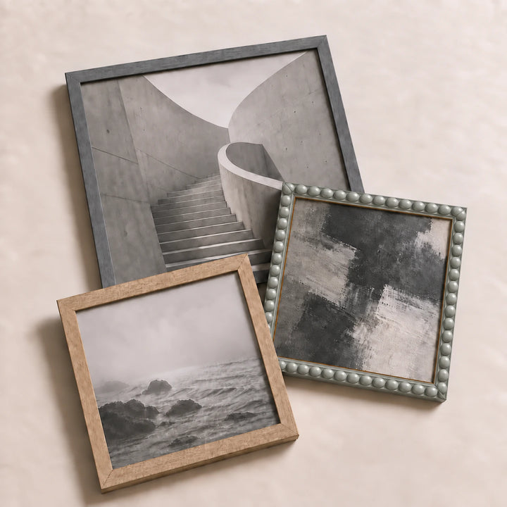 A collection of grey picture frames lying flat with varied edge-to-edge artwork