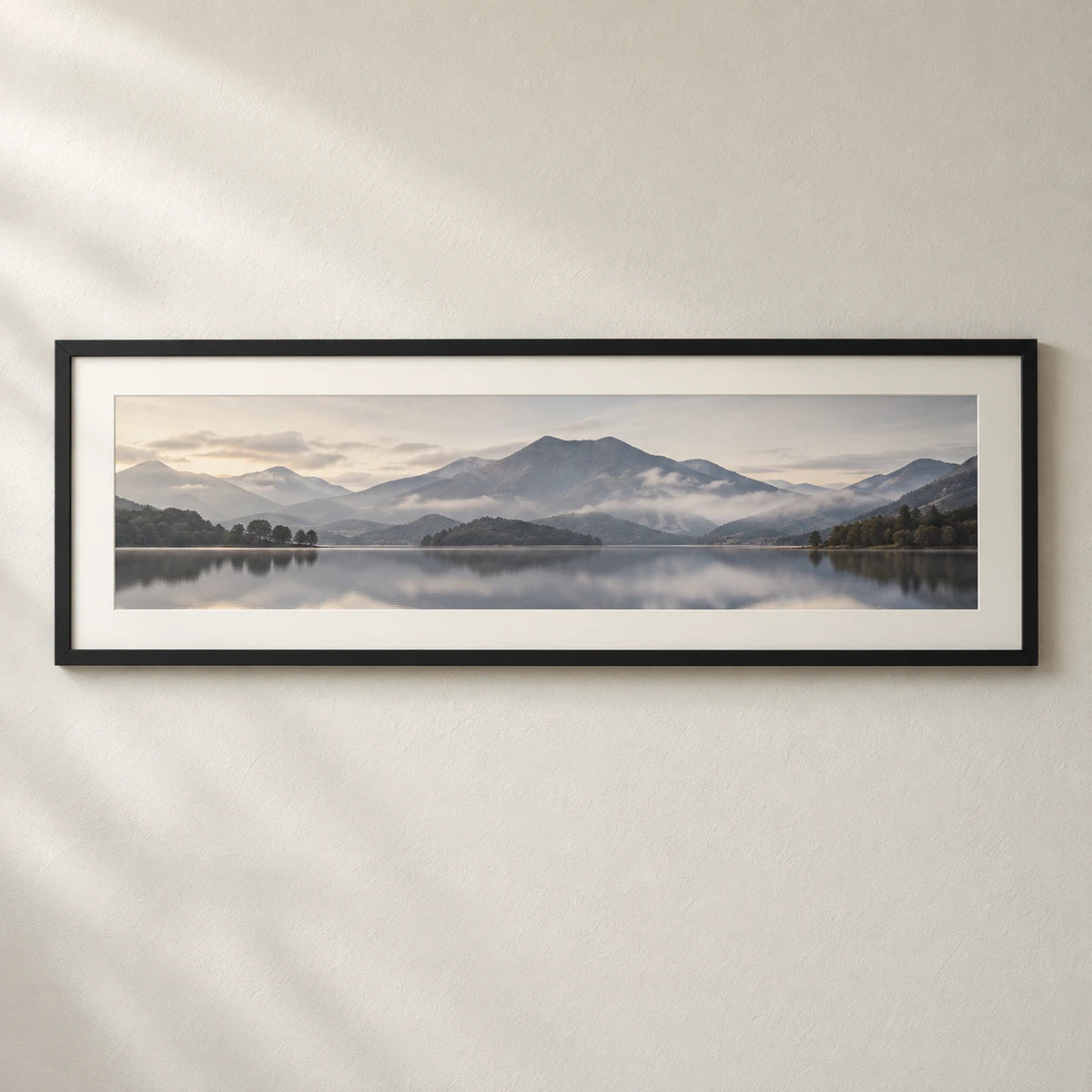 A panoramic mountain and lake photograph displayed in a wide black frame