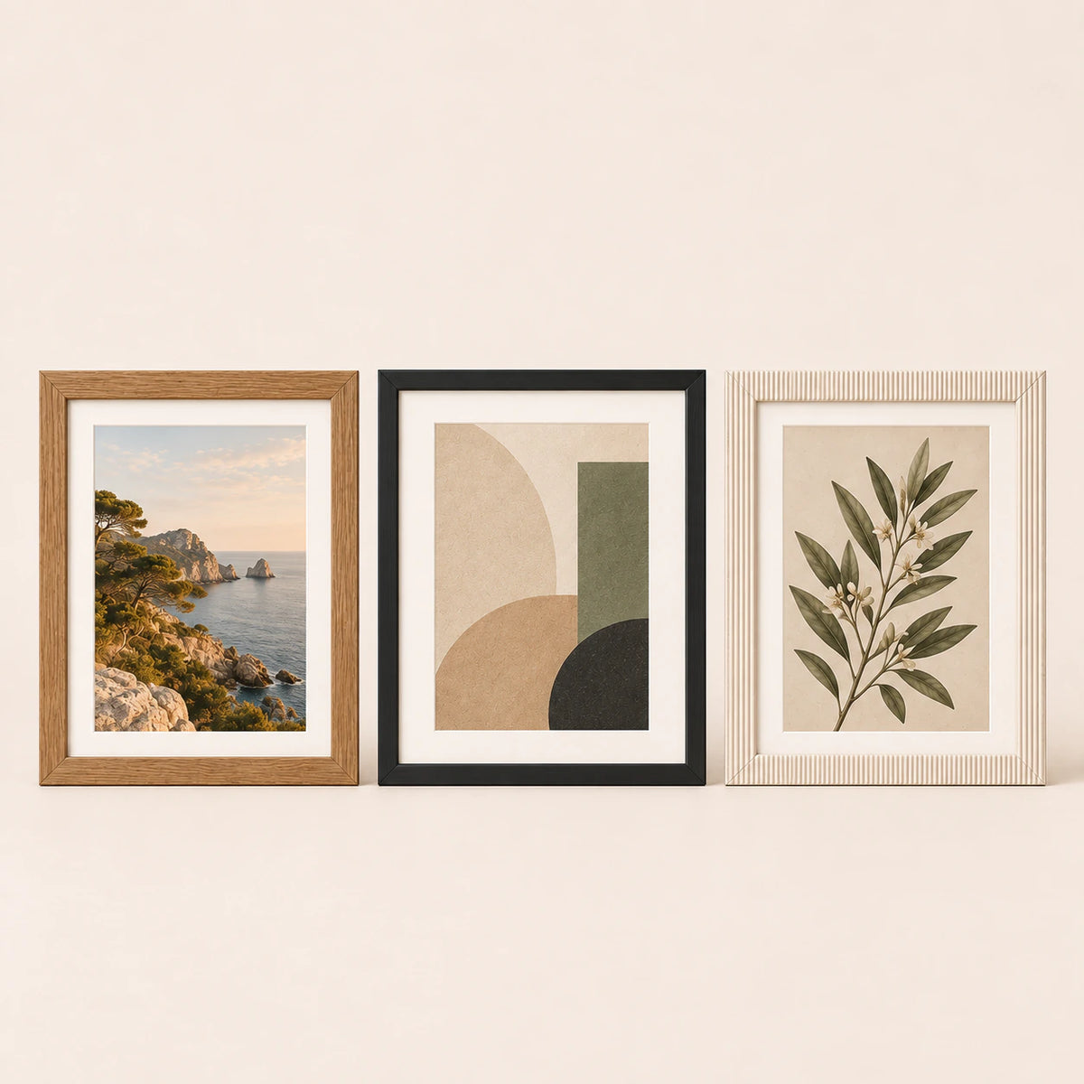Three 15 by 20 centimetre picture frames in oak, black and cream finishes with varied artwork