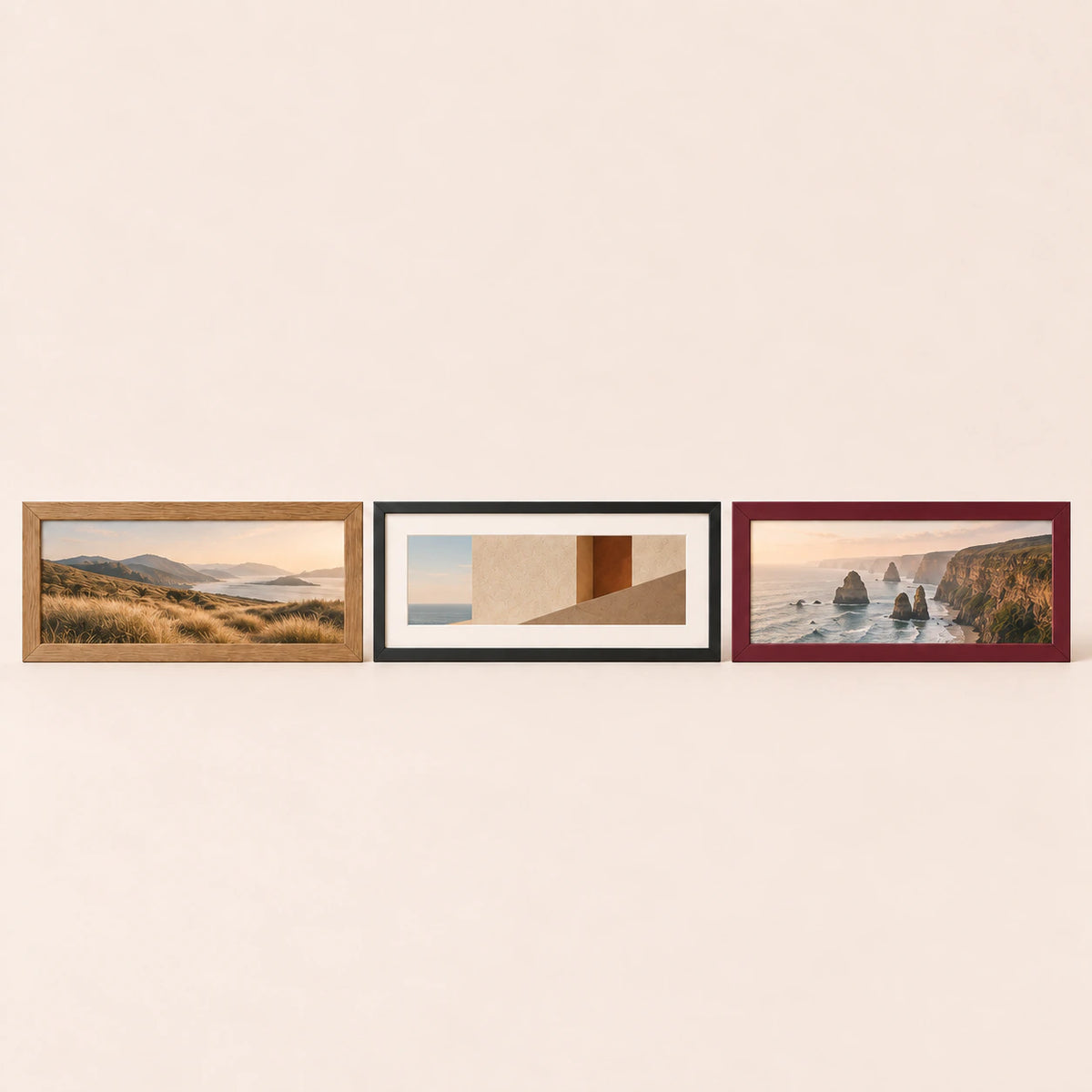 Three 36 by 18 inch panoramic picture frames in oak, black and burgundy finishes with varied artwork